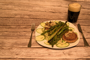 Salad with gratinated camembert and fresh green asparagus and a glass of black beer