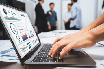 Analyst team uses BI Fintech on a laptop to analyze financial data on blurred background. Business people analyze BI dashboard for insights power into business marketing planning. Prudent - obrazy, fototapety, plakaty