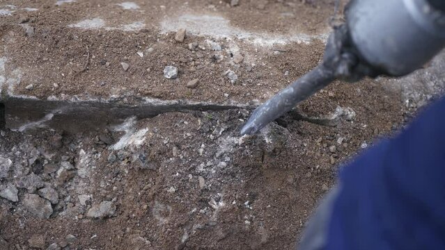 road works on a gas pipeline, prising up the asphalt of a road with a jackhammer to expose a gas connection