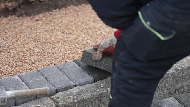 Installing new sidewalk made of concrete interlocking paving blocks, slow motion