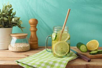 Infused water with lemon and cucumber on wooden table. Detox, diet, healthy eating or  weight loss concept background