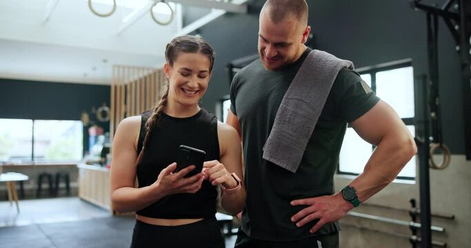 Phone, fitness and couple in gym with networking on the internet for exercise program. Smile, sports and young man and woman athletes on cellphone for workout schedule together in health center.