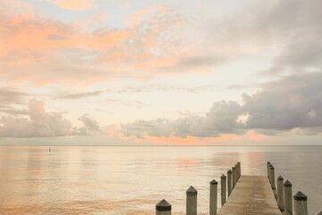Closeup of a wooden dock stretching over a body of tranquil water at sunset in Fairhope