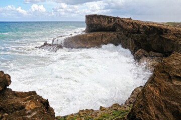 Majestic ocean cliff with powerful waves crashing against it in Puerto Rico