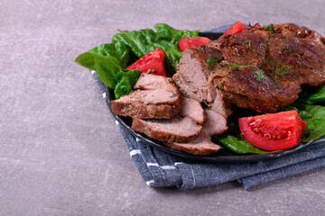 Roasted pork neck served with vegetables and cut into slices. Hot meat meal with spices