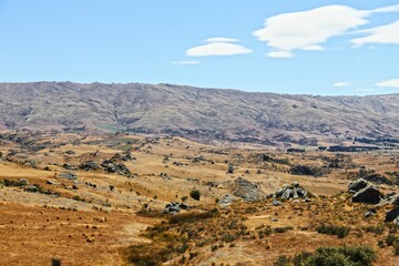 Scenic landscape of mountains and valleys in a dry, arid climate in New Zealand.