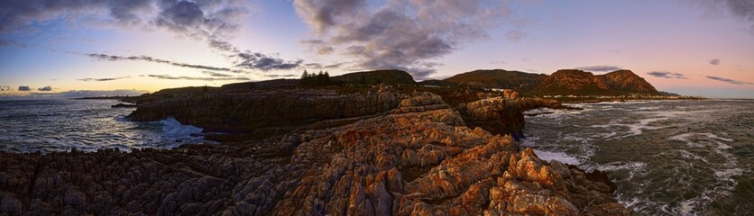 Panoramic view of the rocky shoreline and ocean at sunset. Hermanus, Western Cape.