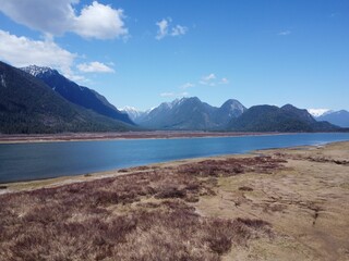 Drone view of a lake with lush mountains in the background