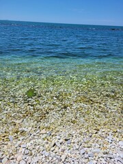 Obraz premium water and gravel on the beach near the shore of the lake