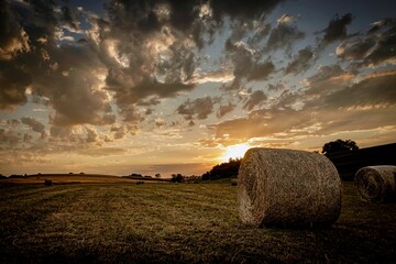 a hay roll in a rural field at sunset
