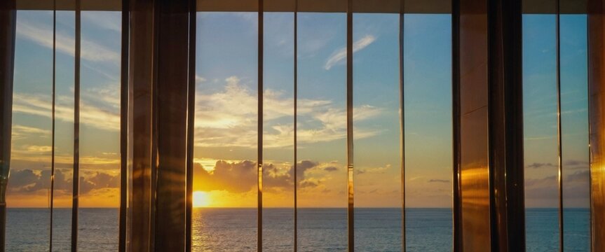 Reflex&atilde;o do nascer do sol e do mar na janela de vidro no resort de hotel de luxo