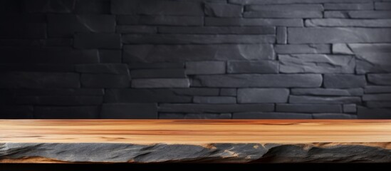 A hardwood table sits on a wood flooring in front of a black brick wall, giving an automotive tire a sleek backdrop. The landscape is reflected in the shiny wood stain finish