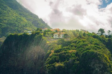 Fototapeta na wymiar Rustic, old house perched atop a rocky mountain peak in Madeira Island