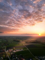 Mesmerizing view of the bright sunset sky over the green fields and towns