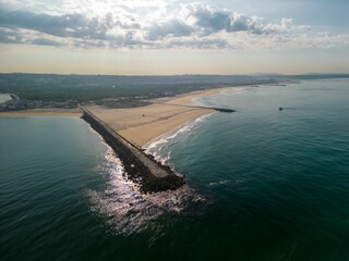 Stunning aerial view of the shoreline Cova do Vapor beach in Trafaria, Portugal