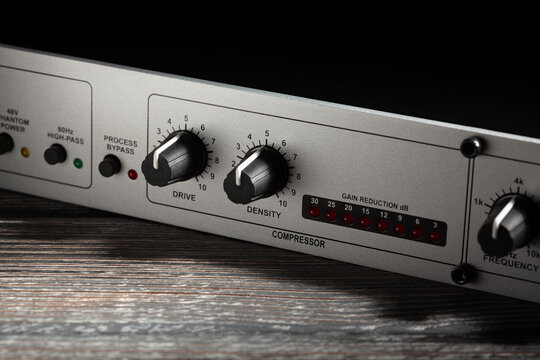 mic preamp processor compressor closeup on wood background
