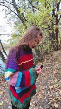 Girl putting earrings on in autumn forest