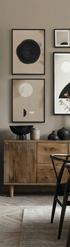 A Japandi-style gallery wall with modern abstract art in wood frames on beige walls complements dark wooden furniture