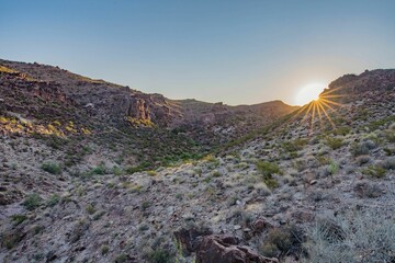 Fototapeta premium the sun is setting on a mountain side as seen from an overlook
