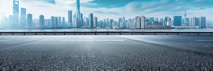 An empty road stretches towards a city skyline in the background, highlighting the urban landscape against the open road