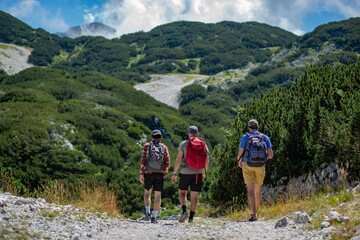 Fototapeta premium Three adventurous individuals exploring a nature trail in Triglav National Park, Slovenia
