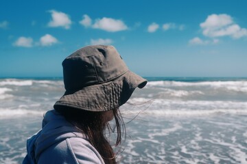Beautiful closeup of a woman standing near the sea with a blurry background