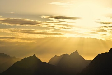 Silhouetted mountain peaks against a stunning sunset sky