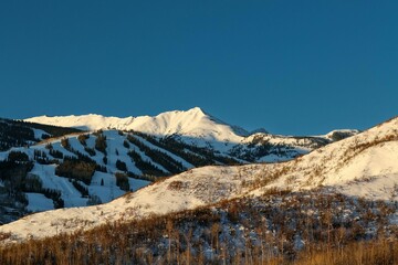 Breathtaking winter landscape with snow-capped mountain peaks and trees in Snowmass at Aspen
