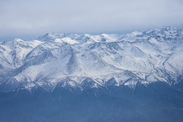 Scenic aerial view of snow-capped mountain peaks covered in fog.