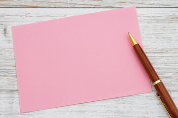 Blank pink greeting card with pen on wood - 771542278