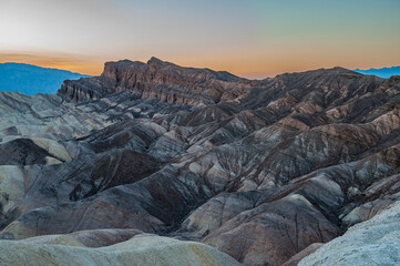 View from Zabriskie Point at dusk. Death Valley National Park in Inyo County of Mojave Desert, California is the hottest place on earth with a temperature of 56,7 °C recorded in 1913. - 771542444