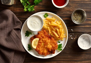 Weiner schnitzel with potato fries. Top view, flat lay