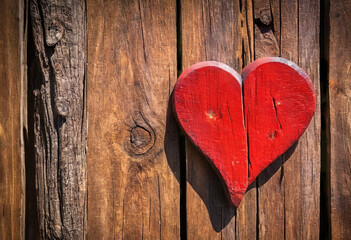 Bright red heart as a symbol of love and friendship on the wooden background