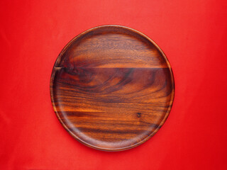 wooden plate or container for placing food on. on a luxurious red background kitchen equipment