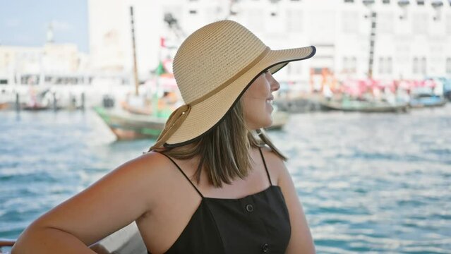 Smiling woman in hat enjoying a sunny day on a traditional boat at dubai creek