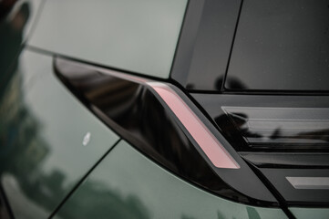 Tail lights closeup. The left rear light on a new modern electric sedan car. Modern concept super car exterior design detail - headlight. Back view. The concept of the future. - obrazy, fototapety, plakaty