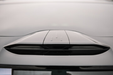 Headlight the car from above above the trunk. Stop signal. Back view. Luxury car outdoors. Exterior of prestige modern electric car. Supercar design detail. Concept of future.