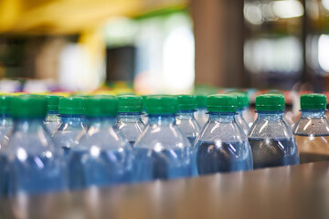Blue plastic half liter small volume mineral water bottles with green cap in store, supermarket...