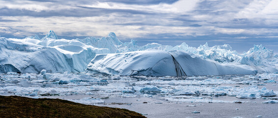 Eisberge des Kangiagletschers sammeln sich im Eisfjord bei Ilulissat in Grönland und schwimmen...