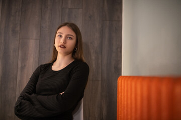 Portrait of a young beautiful long-haired girl in dark clothes in a low key.