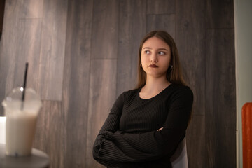 Portrait of a young beautiful long-haired girl in dark clothes in a low key.