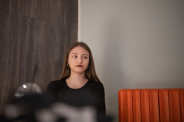 Portrait of a young beautiful long-haired girl in dark clothes in a low key.