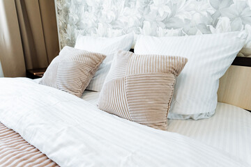 A comfortable bed with white linens in a hotel room with hardwood flooring