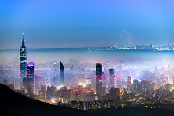 A layer of white clouds and mist over Taipei City, together with the city lights, form a colorful...