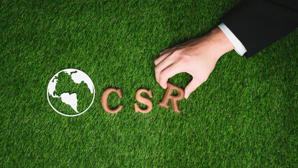 Hand arrange wooden alphabet text in CSR on biophilic background with Earth sign as eco symbol for...