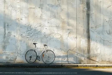 Foto op Plexiglas A bike is parked against a wall with a shadow cast on it. © Zoraiz