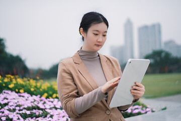 Professional Woman Using Tablet in Urban Park - 771576261