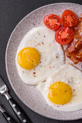English breakfast with fried eggs, bacon, beans, tomatoes, spices and herbs