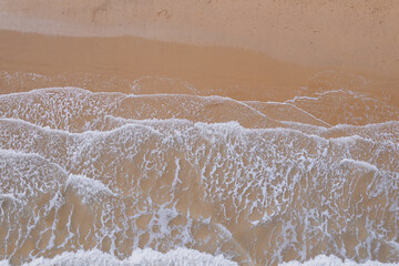 Fototapeta na wymiar Serene Beach Waves Meeting Sandy Shoreline