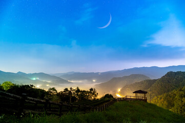 Spring sky symphony: The charming crescent moon hangs in the sky. Early morning view of tea...